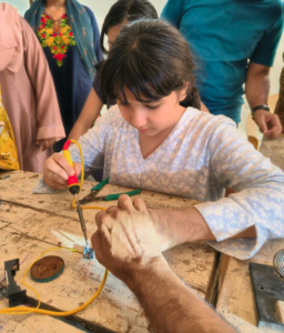 A girl fixes something at RepairCafe Collective India